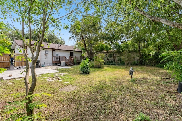 view of yard featuring a wooden deck and a patio