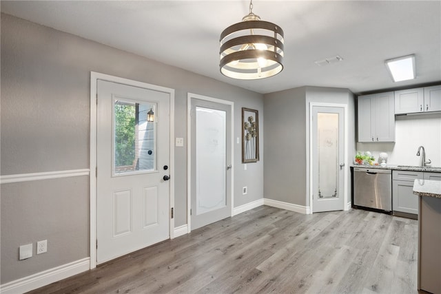 interior space featuring an inviting chandelier, sink, and light hardwood / wood-style flooring