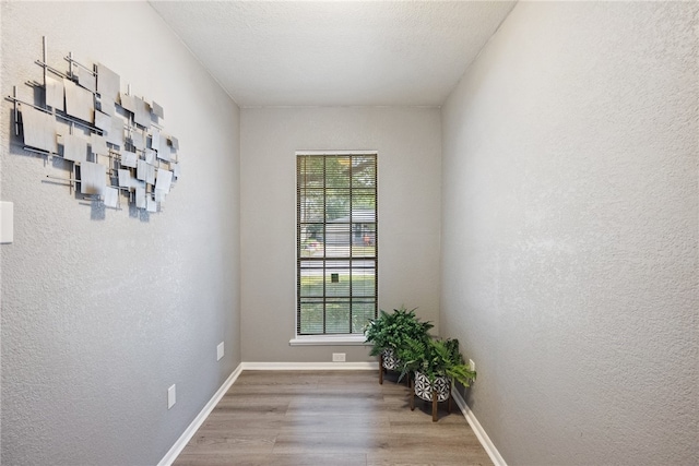 empty room with wood-type flooring and a textured ceiling