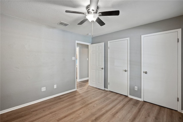 unfurnished bedroom with ceiling fan and light hardwood / wood-style flooring