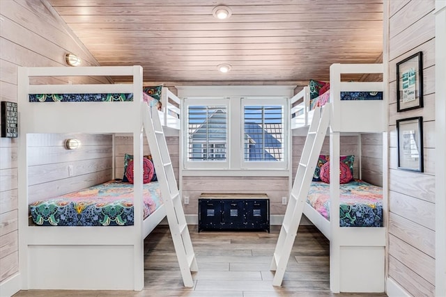 bedroom featuring wood walls, wood ceiling, vaulted ceiling, and wood finished floors