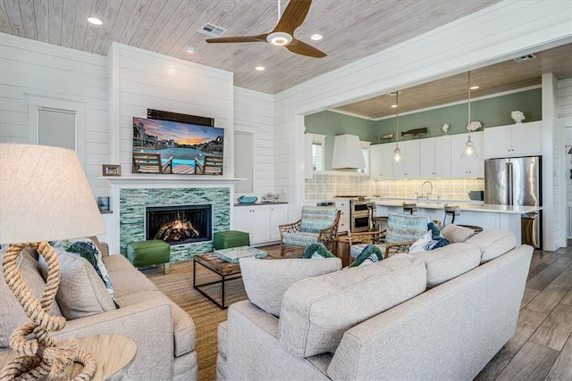 living room with wood ceiling, visible vents, a fireplace, and wood finished floors