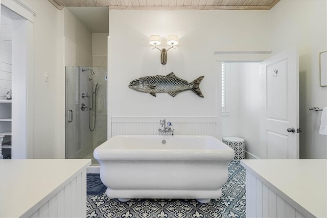 full bath with a soaking tub, wainscoting, a shower stall, and tile patterned floors