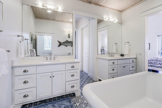 bathroom featuring wood ceiling, two vanities, a sink, and a freestanding bath