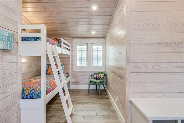 bedroom featuring lofted ceiling, wooden ceiling, recessed lighting, wood walls, and light wood finished floors