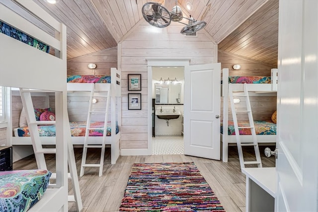 bedroom with lofted ceiling, wooden ceiling, and wooden walls