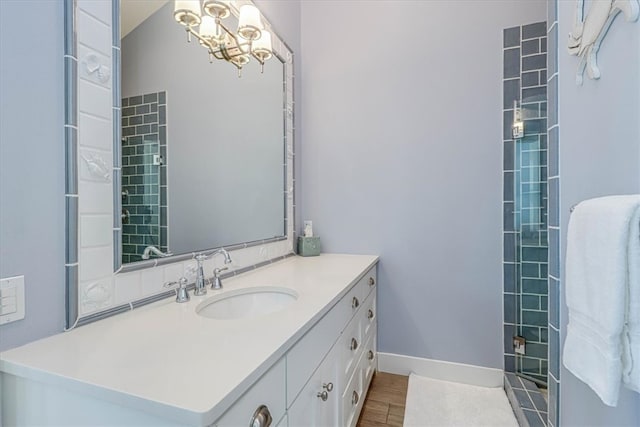 bathroom with an inviting chandelier, baseboards, wood finished floors, and vanity