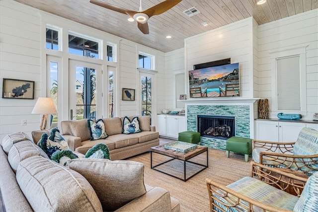 living area featuring visible vents, recessed lighting, ceiling fan, a tile fireplace, and wood ceiling