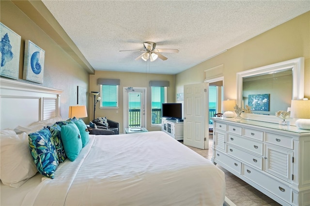 bedroom featuring a textured ceiling, light tile patterned floors, ceiling fan, and access to exterior