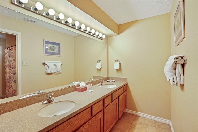 bathroom with vanity, a textured ceiling, and tile patterned floors