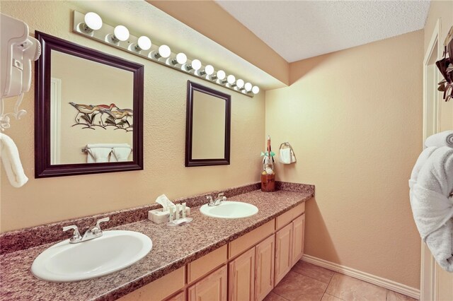 bathroom featuring tile patterned flooring, vanity, and a textured ceiling