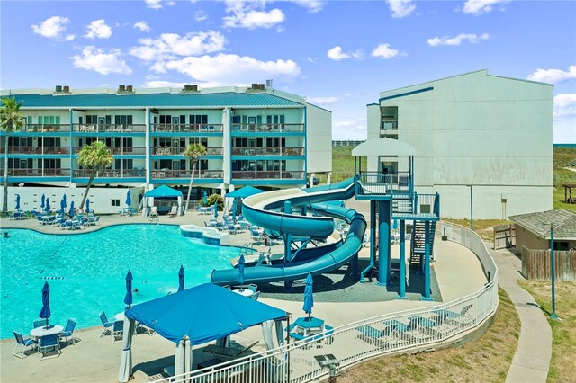 view of pool featuring a water slide and a patio