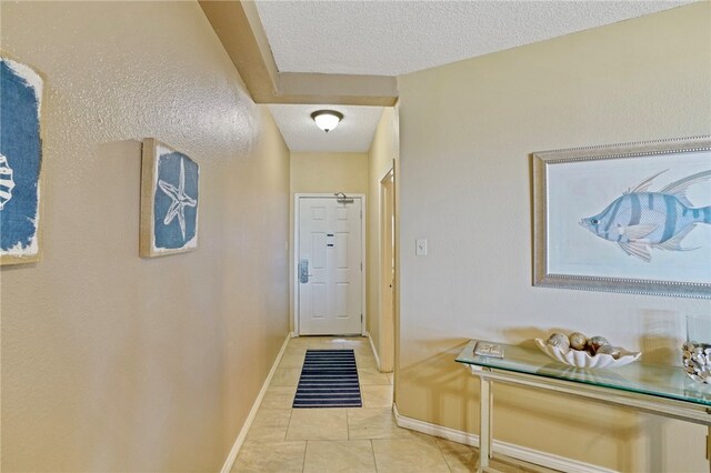 doorway with a textured ceiling and light tile patterned floors