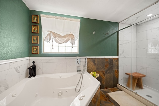 bathroom with tile walls and separate shower and tub