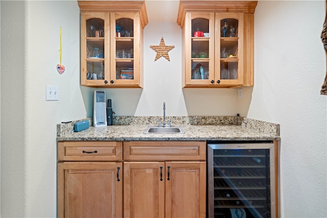 bar with sink, beverage cooler, and light stone countertops