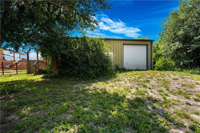 view of yard with a garage and an outbuilding