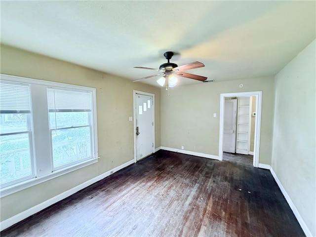 interior space featuring baseboards, wood finished floors, and a ceiling fan