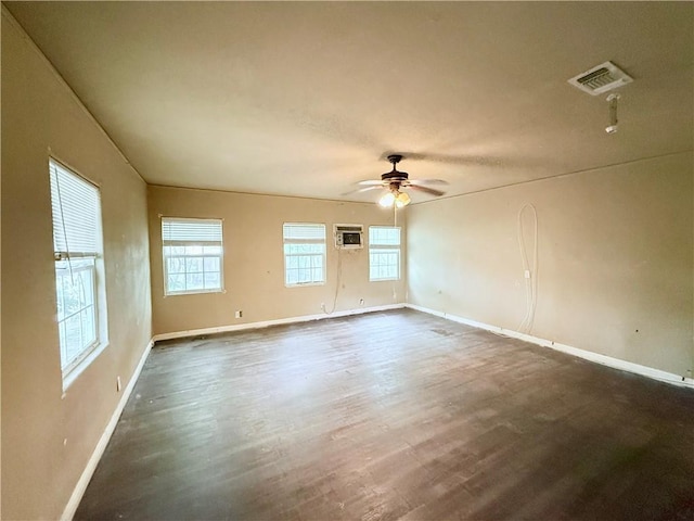 unfurnished room featuring a ceiling fan, dark wood finished floors, visible vents, baseboards, and an AC wall unit