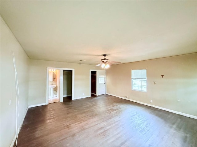 interior space featuring dark wood-style flooring, baseboards, and ceiling fan