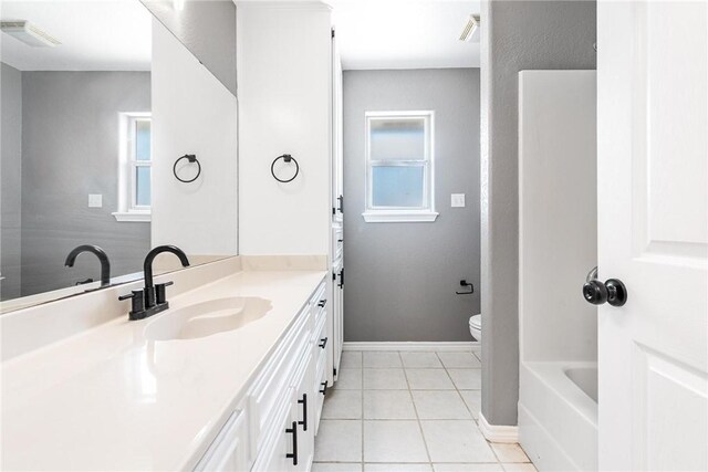 13948 Lighthouse Dr, Corpus Christi, TX 78418 - full bathroom with vanity, toilet, tile patterned flooring, and baseboards