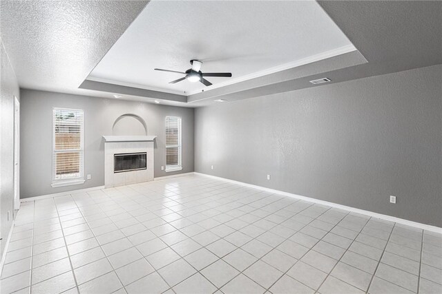 13948 Lighthouse Dr, Corpus Christi, TX 78418 - unfurnished living room with a tray ceiling, ceiling fan, a textured wall, a tile fireplace, and baseboards