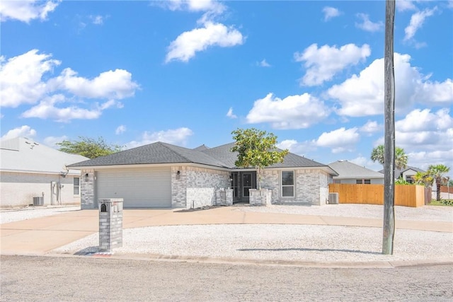 13948 Lighthouse Dr, Corpus Christi, TX 78418 - view of front facade with a garage, driveway, central AC, and stone siding