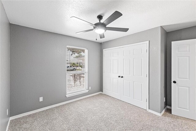 13948 Lighthouse Dr, Corpus Christi, TX 78418 - unfurnished bedroom with a closet, carpet flooring, a textured ceiling, ceiling fan, and baseboards