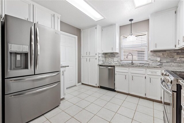 13948 Lighthouse Dr, Corpus Christi, TX 78418 - kitchen featuring appliances with stainless steel finishes, a sink, backsplash, and white cabinetry