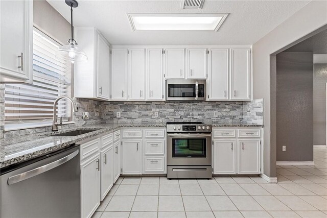 13948 Lighthouse Dr, Corpus Christi, TX 78418 - kitchen featuring stainless steel appliances, a sink, light stone countertops, and white cabinetry
