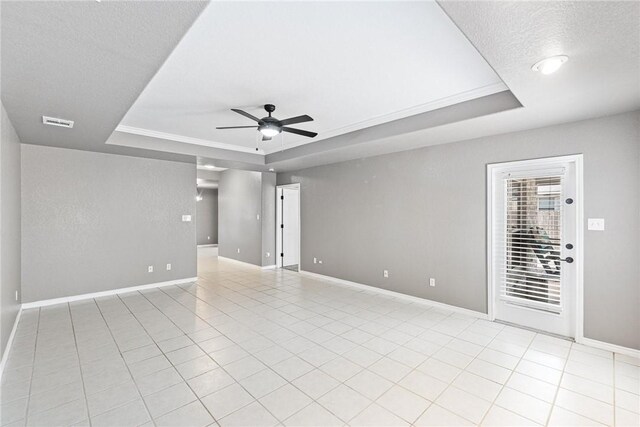 13948 Lighthouse Dr, Corpus Christi, TX 78418 - spare room with a raised ceiling, ceiling fan, baseboards, a textured ceiling, and light tile patterned floors