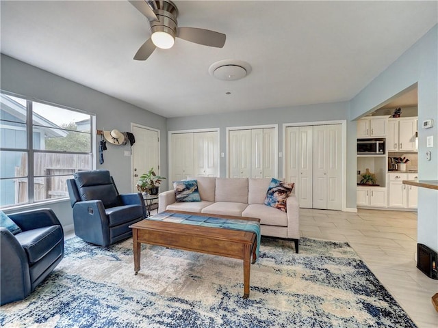 living room with ceiling fan and light hardwood / wood-style flooring