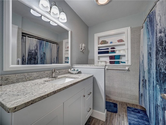 bathroom with vanity, hardwood / wood-style flooring, built in features, and walk in shower