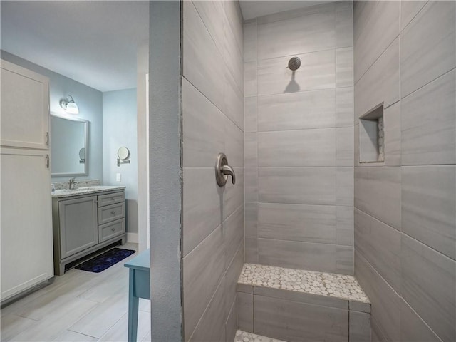 bathroom featuring vanity and tiled shower