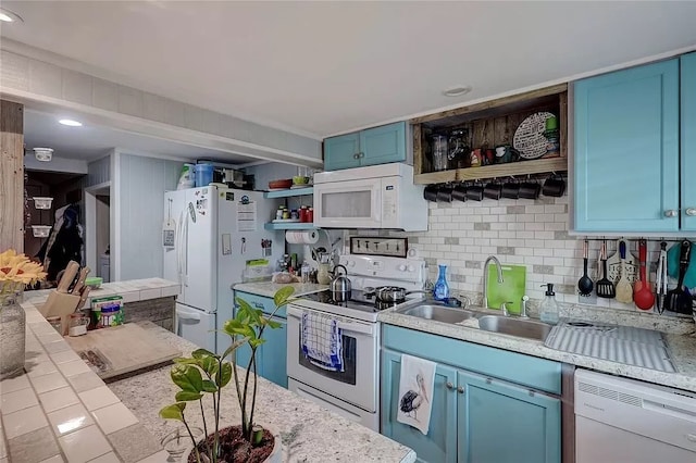 kitchen with blue cabinetry, sink, backsplash, and white appliances