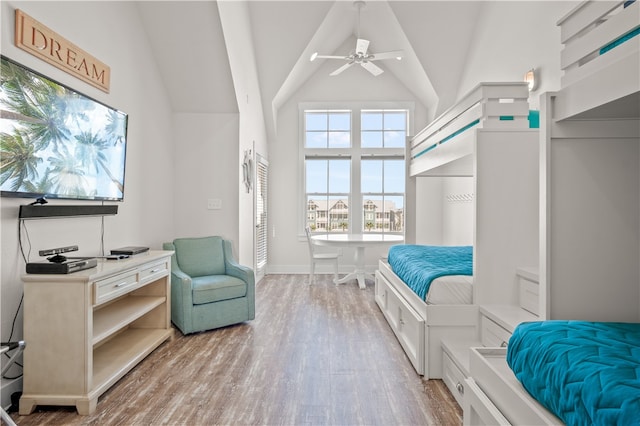 bedroom with light wood-type flooring and high vaulted ceiling