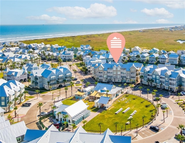 birds eye view of property featuring a water view and a beach view