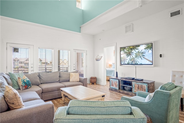 living room with a high ceiling and light wood-type flooring