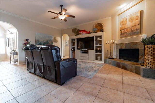 7602 Beau Terre, Corpus Christi, TX 78414 - living room featuring arched walkways, light tile patterned flooring, ceiling fan, a fireplace, and crown molding