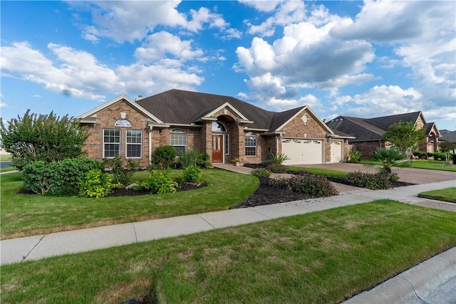 7602 Beau Terre, Corpus Christi, TX 78414 - view of front of home with brick siding, a garage, a front lawn, and driveway