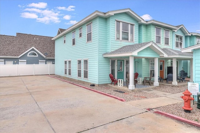 view of front of property with driveway, fence, and a porch