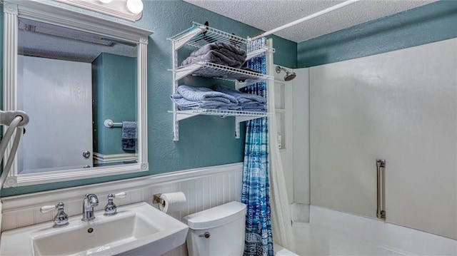 3938 Surfside Blvd Unit 3336, Corpus Christi, TX 78402 - bathroom featuring a textured ceiling, a textured wall, wainscoting, and shower / bath combination with curtain
