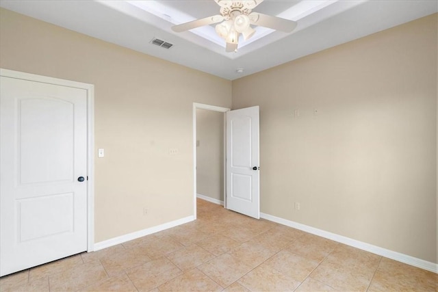 empty room featuring baseboards, ceiling fan, and visible vents