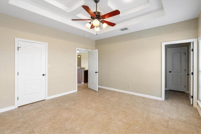 unfurnished bedroom with a ceiling fan, a raised ceiling, baseboards, and visible vents