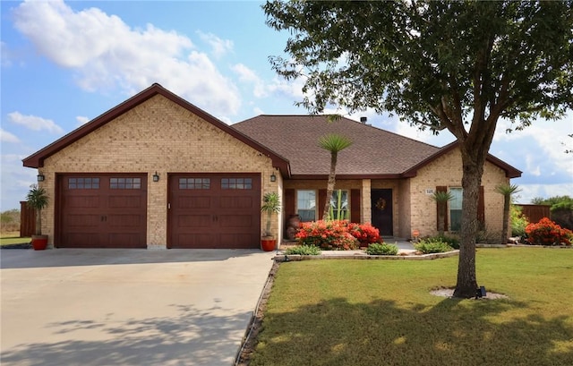 ranch-style house with a front yard, brick siding, concrete driveway, and an attached garage