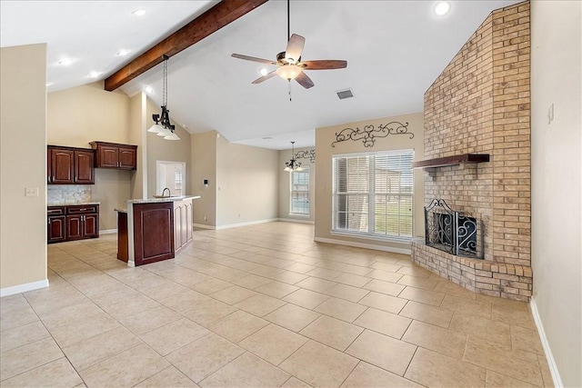 unfurnished living room featuring light tile patterned floors, ceiling fan with notable chandelier, beamed ceiling, visible vents, and a brick fireplace