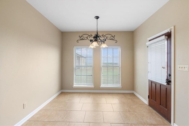 interior space with baseboards, an inviting chandelier, and light tile patterned floors