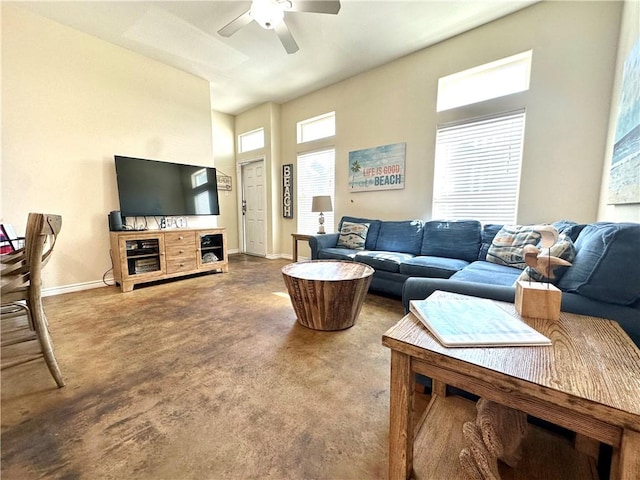 carpeted living area with ceiling fan and baseboards