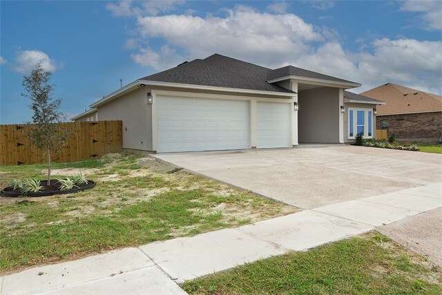 714 Papa Mori Dr, Corpus Christi, TX 78415 - view of front facade featuring an attached garage, stucco siding, concrete driveway, and a shingled roof