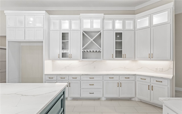 714 Papa Mori Dr, Corpus Christi, TX 78415 - kitchen featuring white cabinetry, light stone countertops, backsplash, light tile patterned flooring, and glass insert cabinets