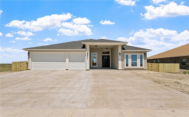 714 Papa Mori Dr, Corpus Christi, TX 78415 - prairie-style house featuring concrete driveway, fence, stucco siding, and an attached garage
